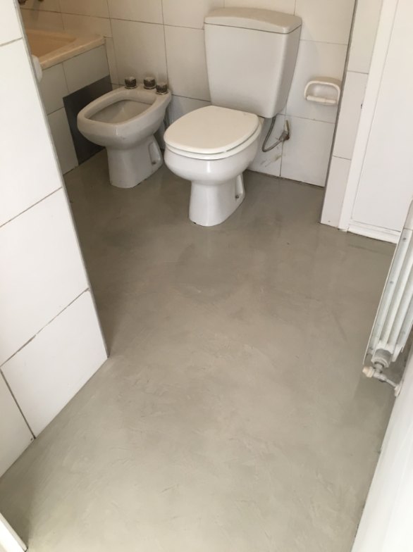 Baño con piso de microcemento gris