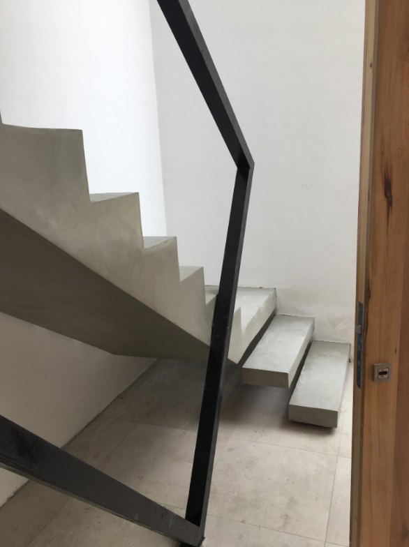 Escalera en L con escalones volados de microcemento