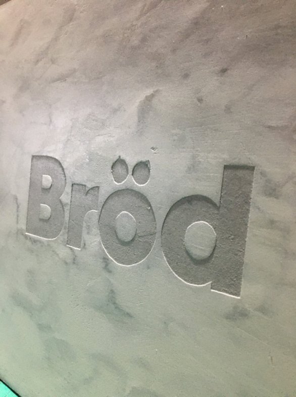 Logo en bajorrelieve integrado en una pared de microcemento