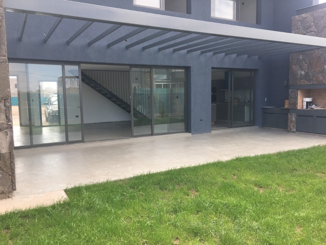 Galería exterior con piso de microcemento junto al jardín